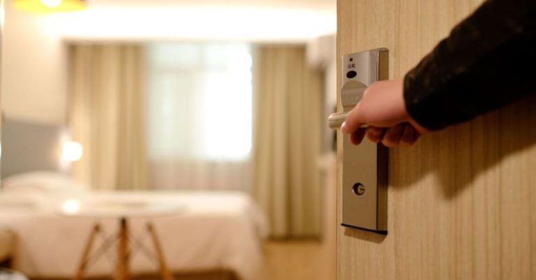 Hotel - Person Holding on Door Lever Inside Room