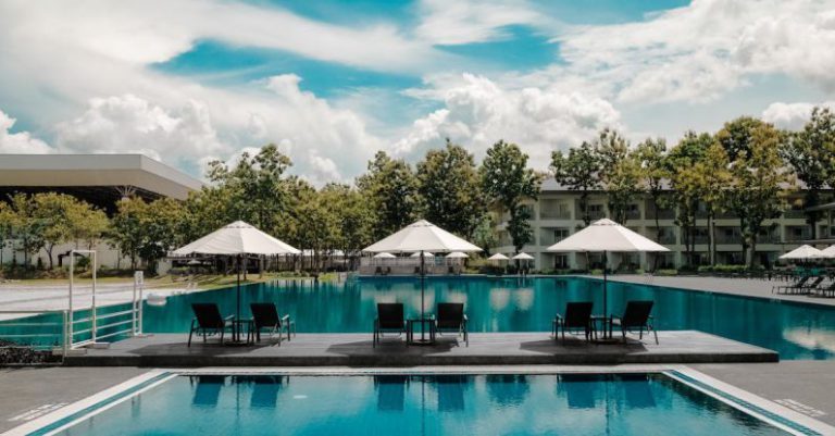 Hotel - Black Outdoor Lounge Chair in Between Blue Swimming Pool Under White Cloudy Blue Sky