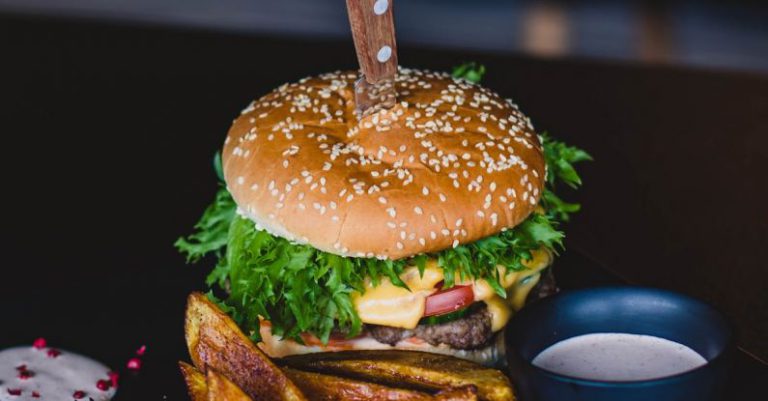 Cuisine - Burger With Fried Fries on Black Plate With Sauce on the side