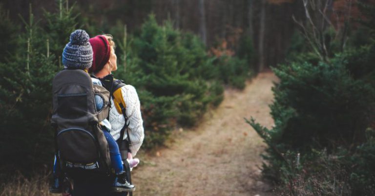 Hiking - Shallow Focus on Blond Haired Woman in White Long Sleeve Shirt Carrying a Baby on Her Back